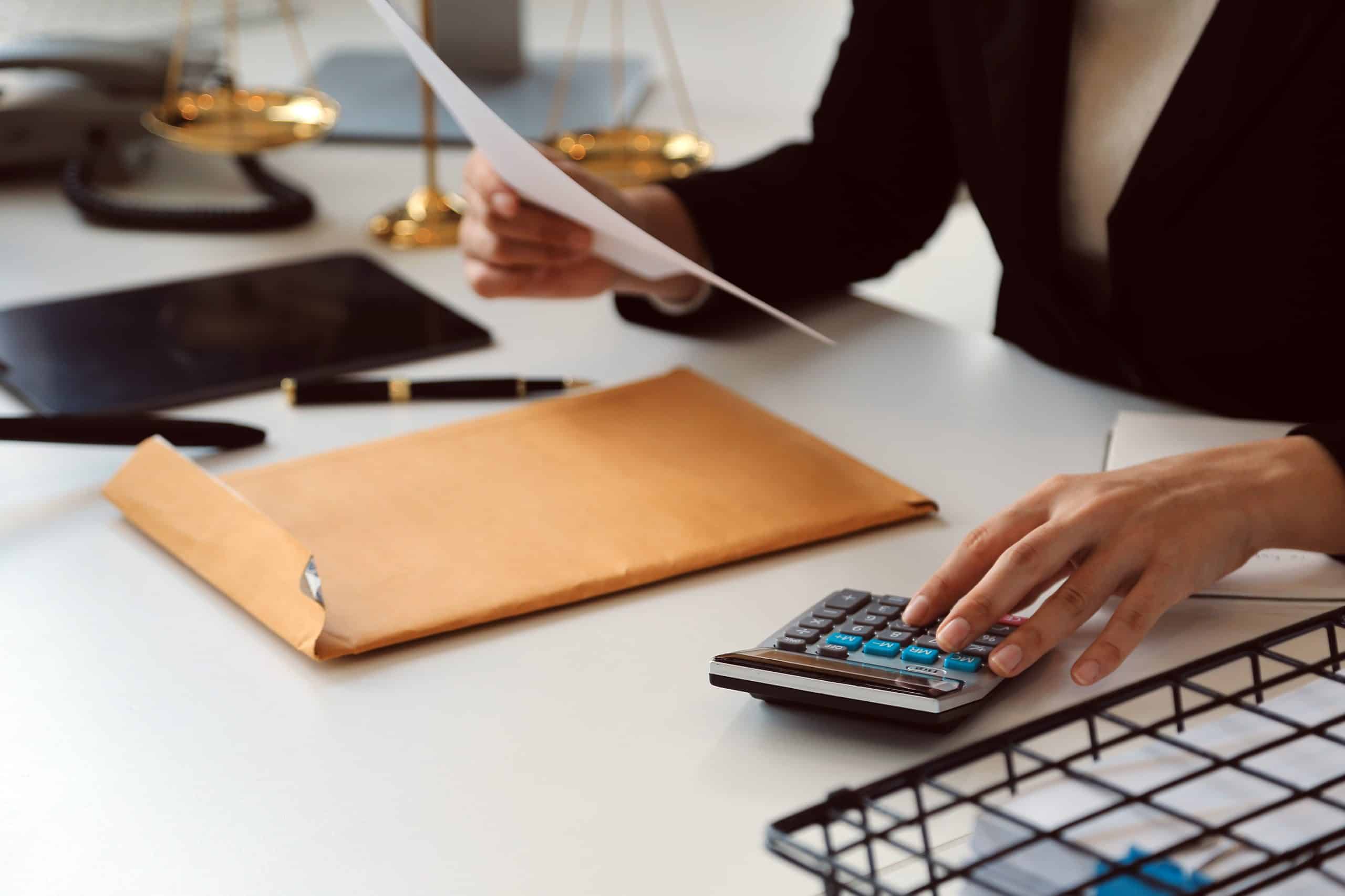 Profesional revisando documentos fiscales, gráficos y calculadora, simbolizando asesoramiento tributario.